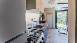 Een moderne keuken met een gasfornuis, een roestvrijstalen spoelbak en houten kastjes.