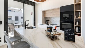 Une cuisine moderne dotée d’un plan de travail en marbre, d’une machine à café et d’un panneau indiquant qu’il s’agit de Casa Laia.