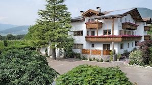 A multi-story building with balconies, a stone facade, and a mountainous backdrop. - Holiday Apartment 'Klementhof No. 2' with Mountain View, Shared Pool and Wi-Fi (Naz-Sciaves)