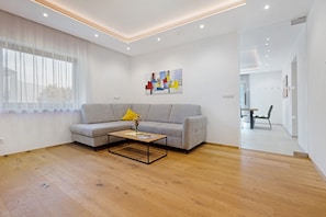 A modern living room with a sofa, coffee table, and artwork on the wall.