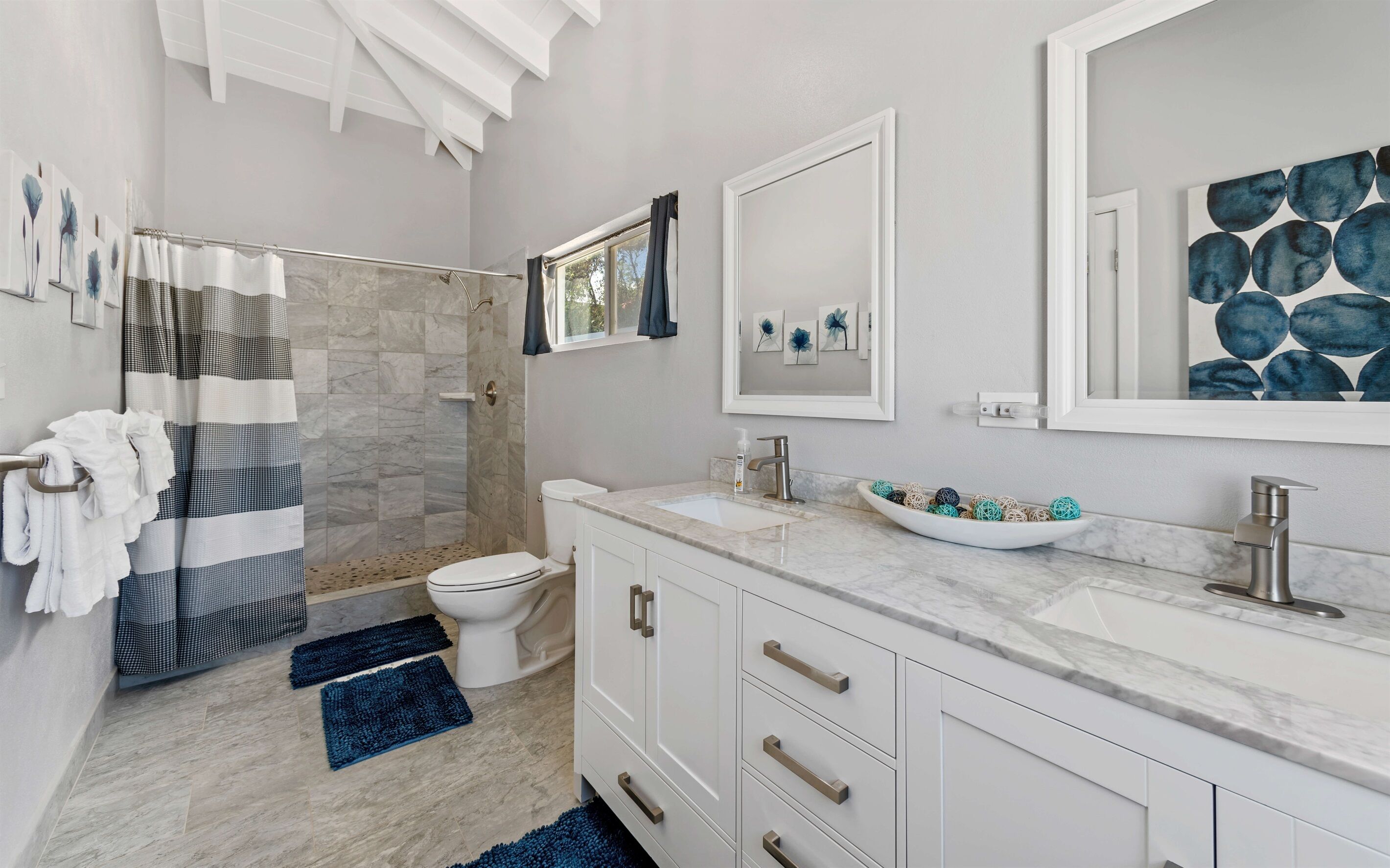 A modern bathroom with a shower, toilet, and sink.