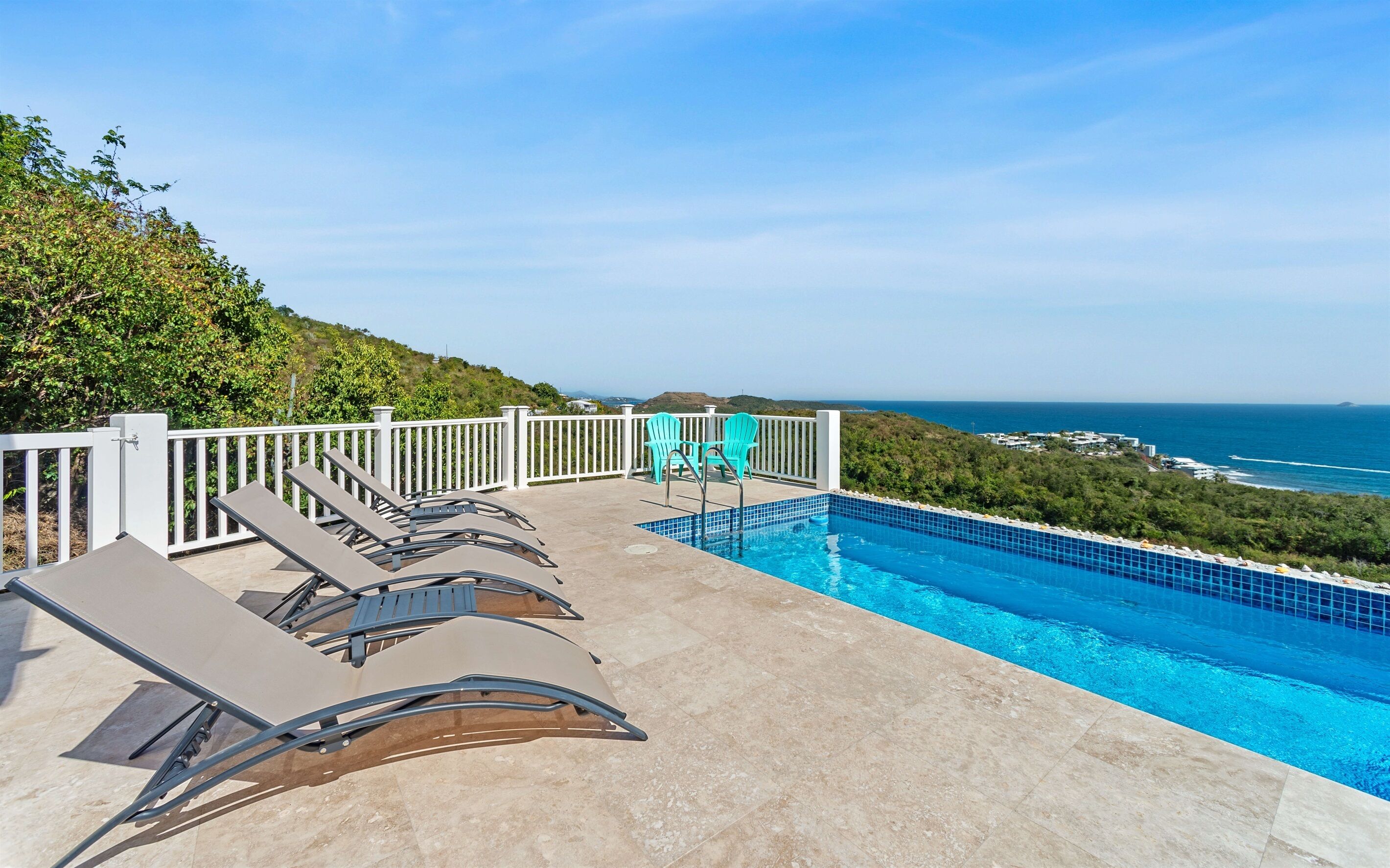 Ein Pool auf dem Dach mit Liegestühlen und Blick auf den Ozean.