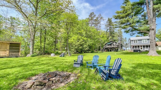 A backyard with a fire pit, blue Adirondack chairs, and a wooden shed. - 2 Adjacent Houses Rented Together!! (Swanton)