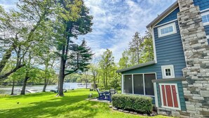 A house with a stone exterior, a screened porch, and a view of a lake. - 2 Adjacent Houses Rented Together!! (Swanton)
