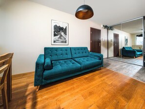 Relax in this stylish living space with a comfortable sofa, framed artwork, and a large mirror.