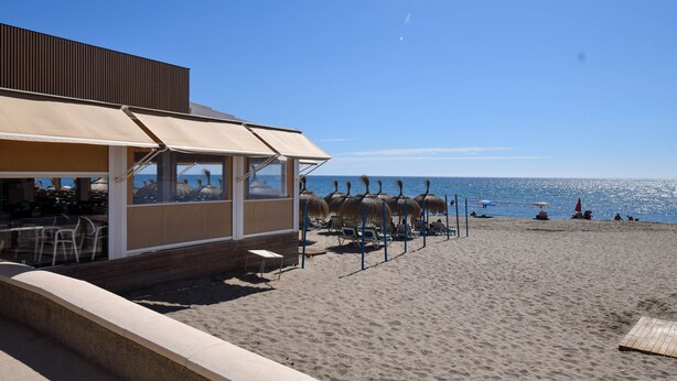 A beachside restaurant with outdoor seating, a wooden deck, and a view of the ocean. - Ref: 263 Apartment with sea views on second line beach in Torreblanca (Fuengirola)