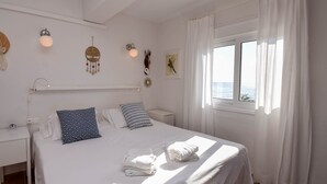 A neatly arranged hotel room with a bed, a bedside table, a window with curtains, and wall decorations including a dreamcatcher and a wall-mounted light fixture. - Ref: 263 Apartment with sea views on second line beach in Torreblanca (Fuengirola)