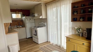 Una cocina compacta con estufa, refrigerador y armarios de madera.
