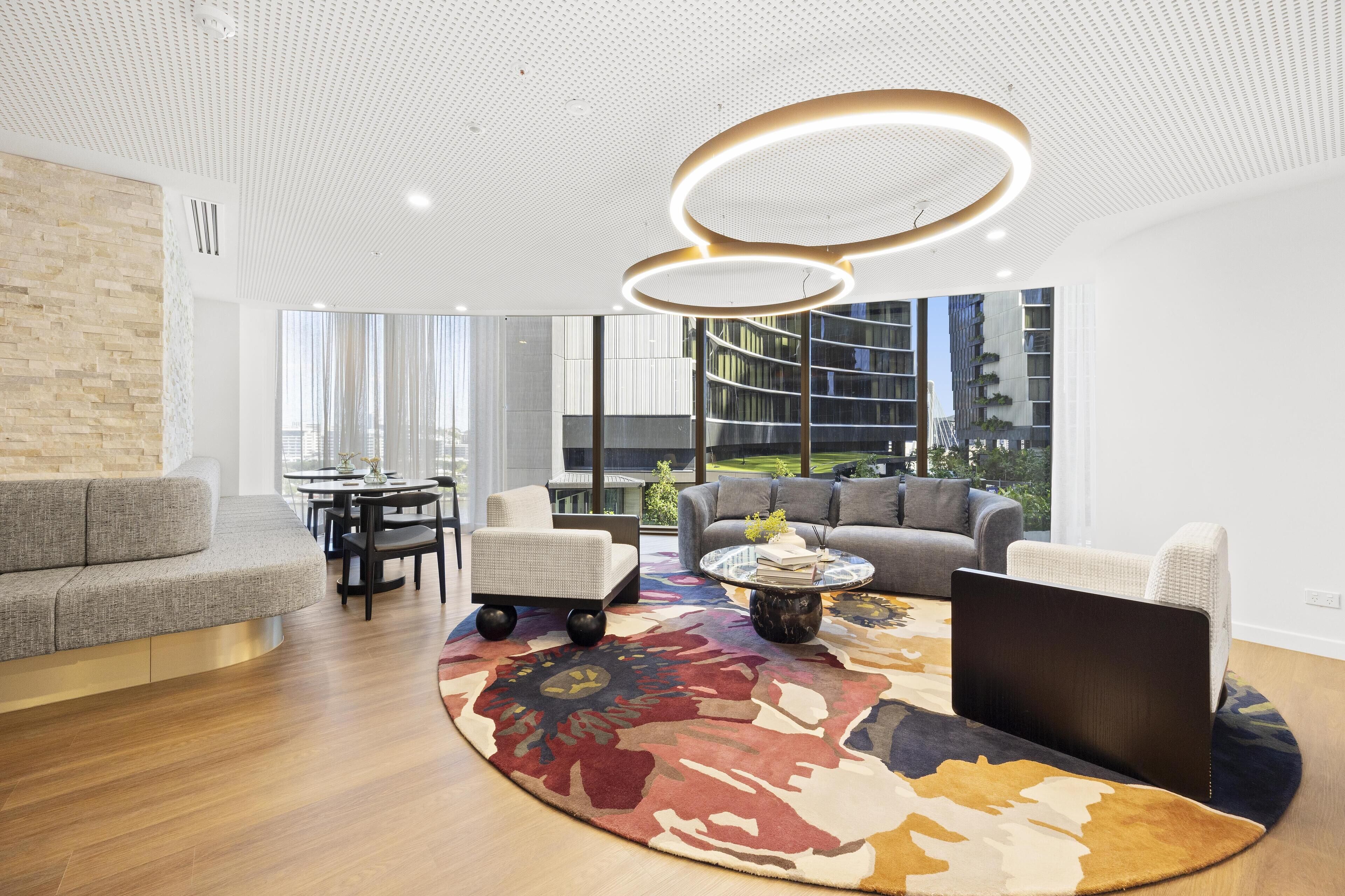 A modern living room with a curved rug, a round coffee table, and a sofa.