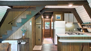 A kitchen with wooden beams, a refrigerator, and a sink. - A-frame Cabin Near Mt. Mitchell | Rustic A-Frame on Private Acre (Burnsville)