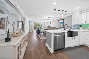 A modern kitchen with a central island, stainless steel appliances, and a view to the outdoor area.