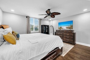 A bedroom with a bed, dresser, and ceiling fan. - Dolphin Point 106C - Harbor Views & Boat Slip (Destin)