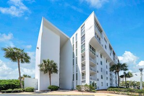 A modern building with a unique architectural design, featuring a prominent white facade and multiple balconies. - Dolphin Point 106C - Harbor Views & Boat Slip (Destin)