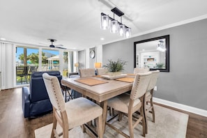A dining area with a wooden table, four chairs, and a ceiling fan.