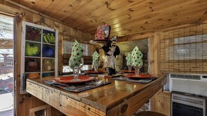 A wooden interior with a bar area, a window with a view, and a decorative fruit display. - NEW LISTING !!!  RUSTIC MEADOW AT LADYBUG LAKE (Morganton)