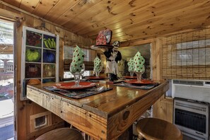 A wooden interior with a bar area, a window with a view, and a decorative fruit display.