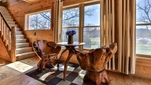 A wooden interior with a staircase, a table with a vase, and large windows. - NEW LISTING !!!  RUSTIC MEADOW AT LADYBUG LAKE (Morganton)