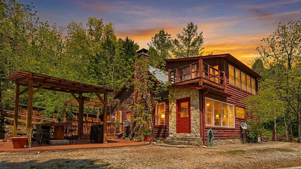 A rustic cabin with a stone foundation, a wooden deck, and a covered outdoor seating area. - NEW LISTING !!!  RUSTIC MEADOW AT LADYBUG LAKE (Morganton)