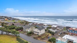 A coastal residential area with houses, a road, and the ocean in the background. - the Zephyr Shore in Roads End (Lincoln City)
