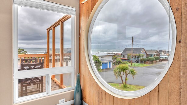 A room with a large window and a smaller window, both with white frames. - the Zephyr Shore in Roads End (Lincoln City)
