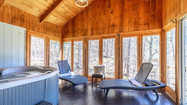 A wooden cabin with a hot tub, two wicker chairs, and a small table. - Spacious Chalet Near Stratton and Mt. Snow w/Indoor Hot Tub, Fireplace, Firepit (Wardsboro)
