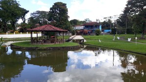 A park with a gazebo, a pond, and a bridge. - House in Guapimirim Condominium (Iconha Guapimirim)