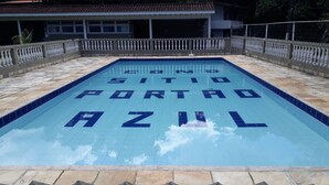 A swimming pool with the words "CINQ SITIO PORTAO AZUL" written on the tiles. - House in Guapimirim Condominium (Iconha Guapimirim)