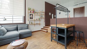 A modern living room with a grey sofa, a wooden table, and a bookshelf. - GuestHost - Milano Bovisa Apartment (Milano)