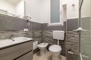 Chuveiro, secador de cabelo, bidê, toalhas de banho