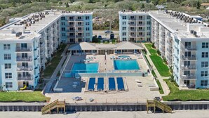 Un hotel de varios pisos con piscina en la azotea, zona de piscina separada y acceso directo a la playa.