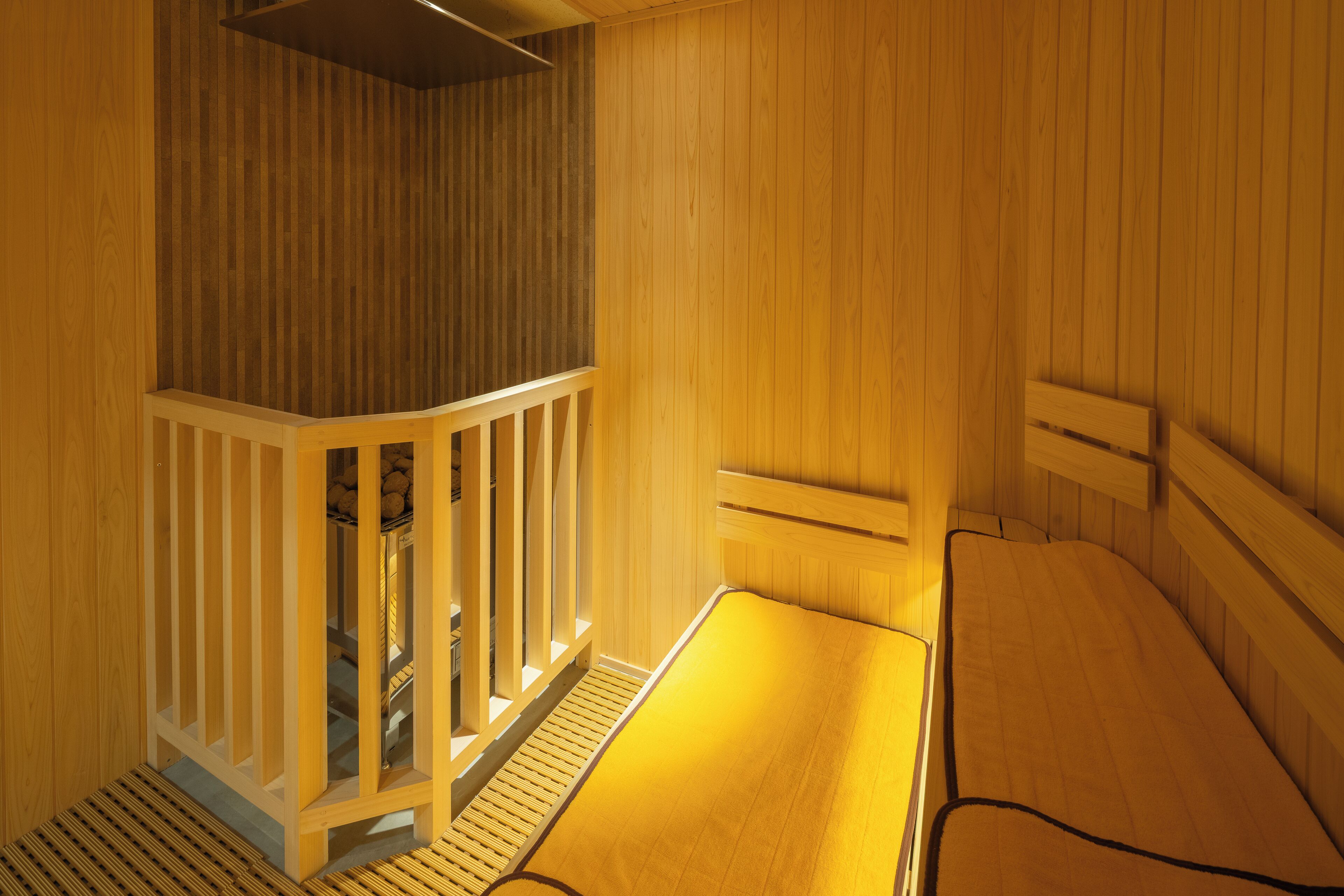 Una sauna in legno con panche e una piccola struttura di legno.