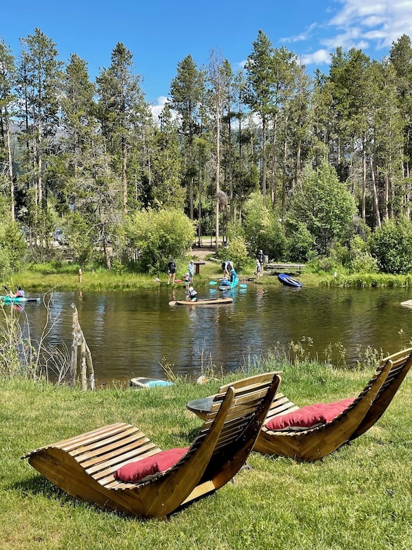 En plats vid sjön med trämöbler och en lugn vattenyta.