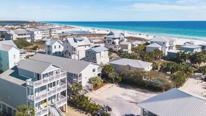 A coastal residential area with beachfront properties, including multi-story buildings with balconies, a beach, and a clear view of the ocean. - Grayt Days by Stay on 30a (Santa Rosa Beach)