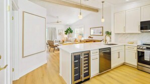 A modern kitchen with white cabinetry, stainless steel appliances, and a central island. - Grayt Days by Stay on 30a (Santa Rosa Beach)