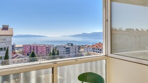 Un balcon offrant une vue sur la ville et les montagnes.