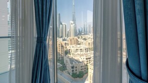 Vista dalla finestra di un grattacielo su un paesaggio urbano con edifici moderni e un grattacielo dominante.