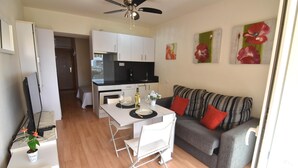 A compact living space with a kitchenette, dining area, and a sofa. - Discover this charming studio in Santa Margarita, Roses! (Roses)