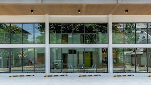 A modern building with large glass windows, a wooden slatted ceiling, and a green vertical garden. - Infinite Hotel Kaset-Senanikom (Bangkok)