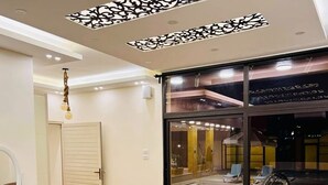 Una habitación con un amplio ventanal corredera que da a una zona de piscina, un tocador blanco con espejo, un sofá estampado de leopardo y suelo de madera.