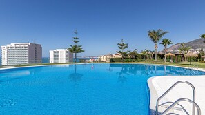 A clear blue pool surrounded by palm trees and a hotel named "ESTIVAL TORREQUEBRADA". - Marvelous views, pools, steps to the beach! REF024 (Benalmádena)