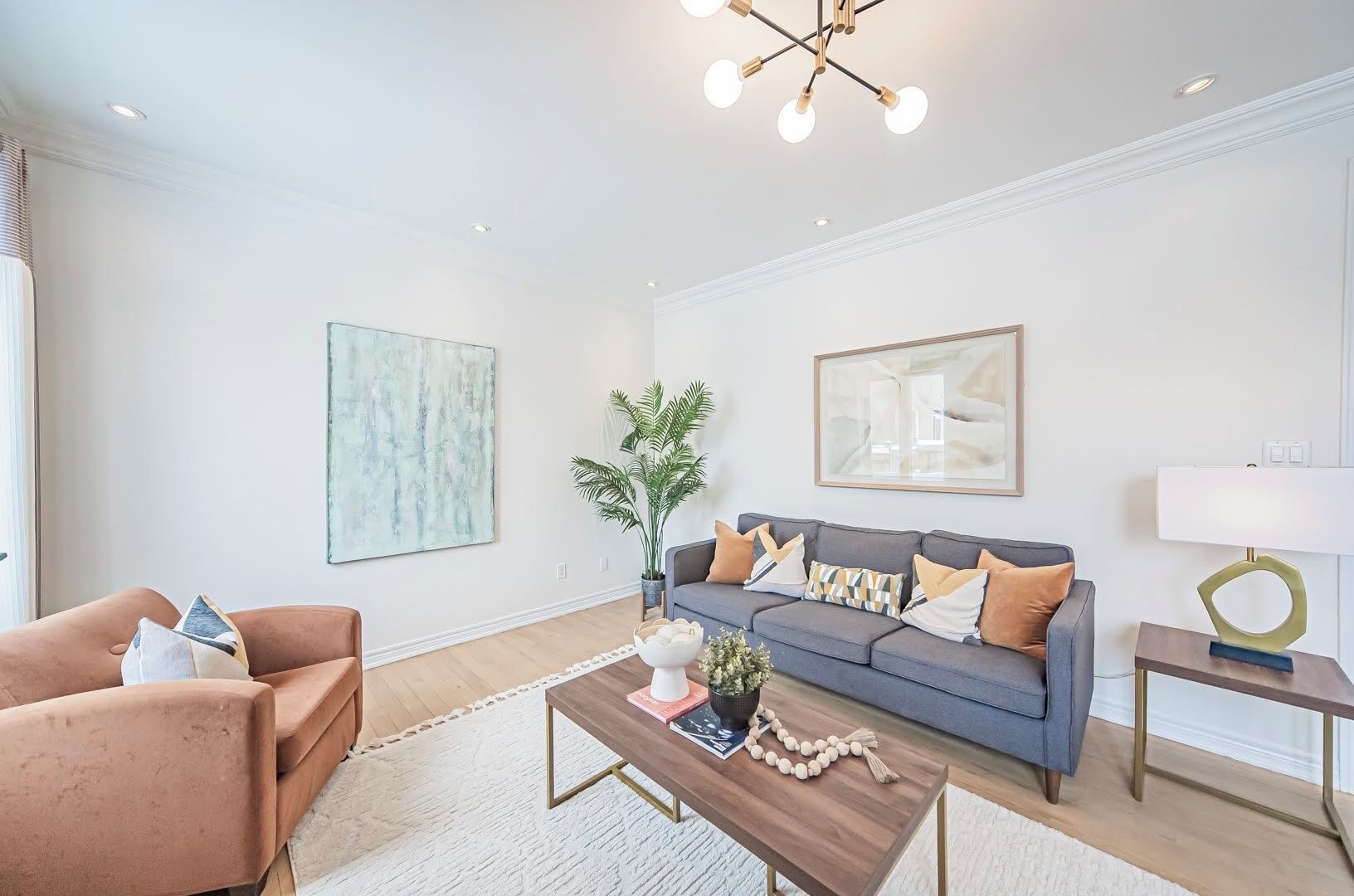 A modern living room with a grey sofa, a brown armchair, a wooden coffee table, and a floor lamp.