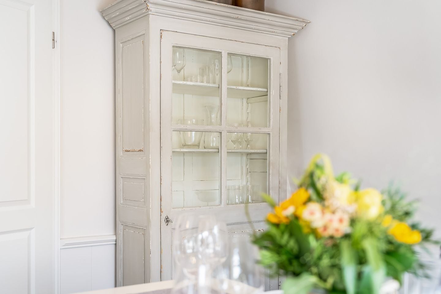 Un mueble blanco con puertas de cristal, un tirador y una cerradura.