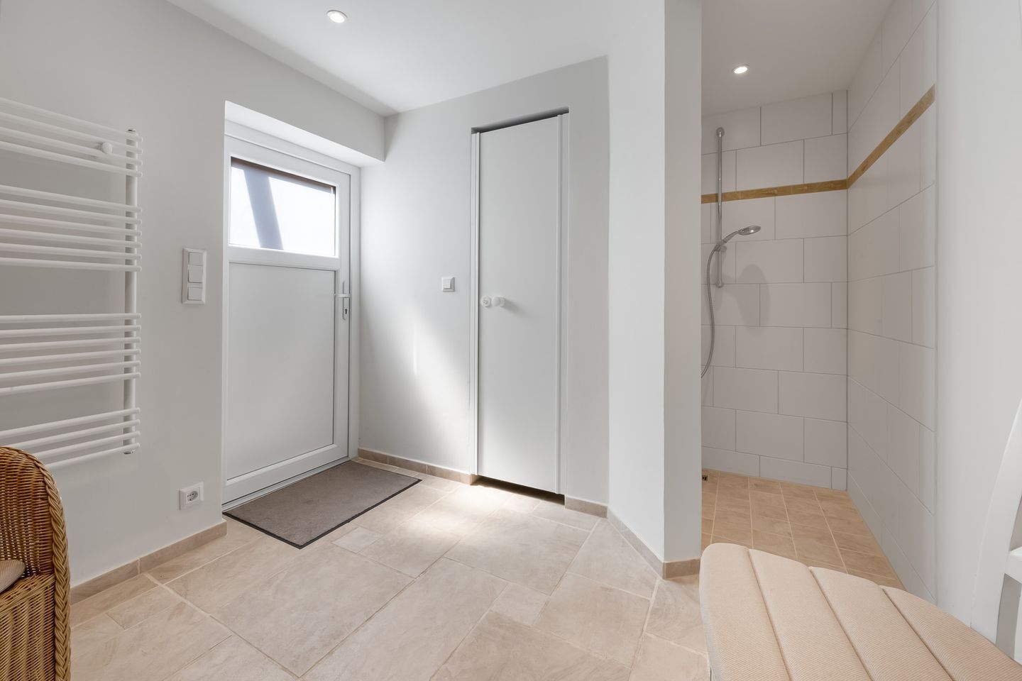 Une salle de bain moderne équipée d’une douche, d’une porte et d’un radiateur.