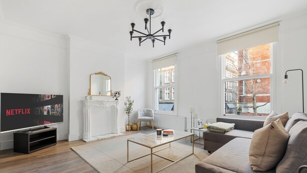 Un salon moderne avec un téléviseur à écran plat, un canapé, une table basse et une cheminée.