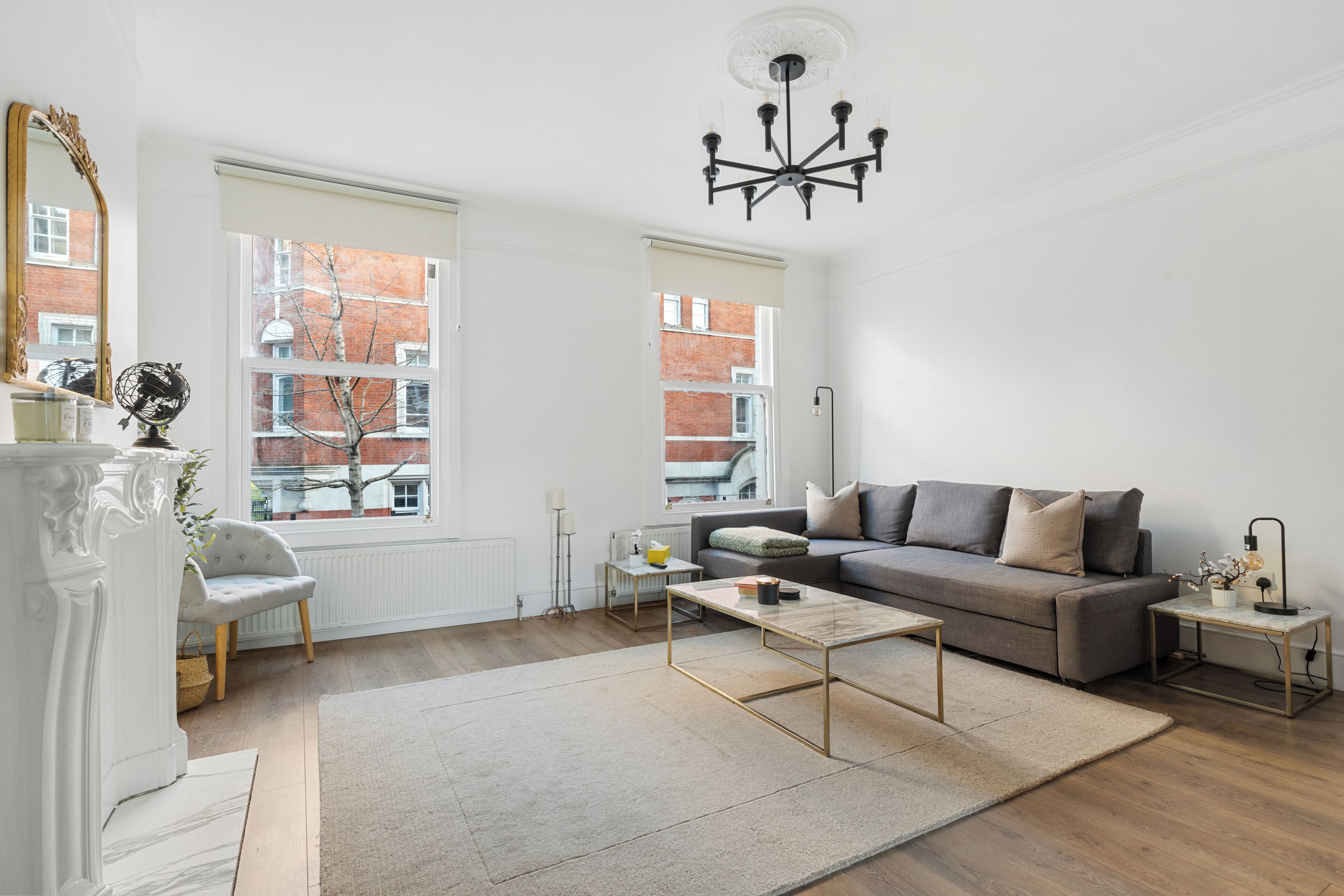 A modern living room with a sofa, coffee table, and a large window.