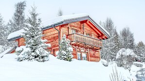 A wooden cabin with a balcony, surrounded by snow-covered trees. - Dendron by Interhome (Ovronnaz)