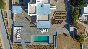 An aerial view of a property with a swimming pool, multiple rooms, and a garden area. - Soho Villa in Paros (Tzanes)