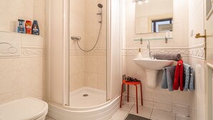 A bathroom with a shower, toilet, sink, and a mirror with lights. - 1 Bed Flat - Sleeps 4 - Pets - Wifi (Praha)
