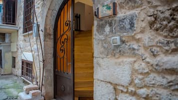 A stone building with a wooden door and a metal gate.