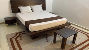 Ein ordentlich eingerichtetes Schlafzimmer mit einem Bett, Nachttischen und einem kleinen Tisch.